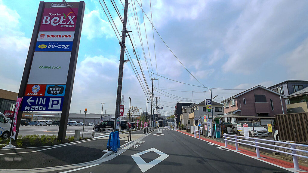 鹿浜西テラスの自立看板(ベルクス・バーガーキング併設)と駐車場入口への進入路