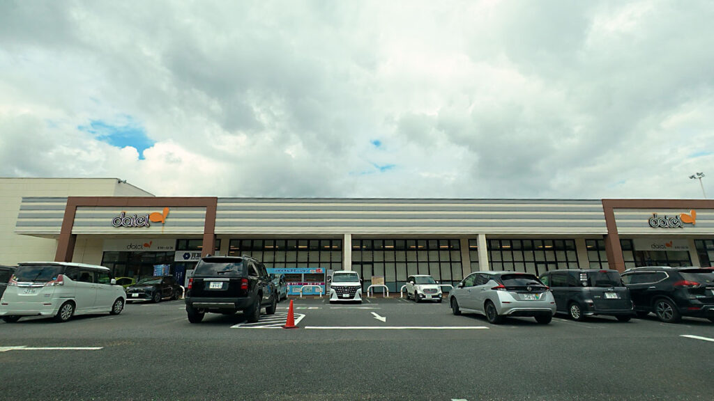 ダイエー津久井店の平面駐車場から見た店舗正面と場内通路